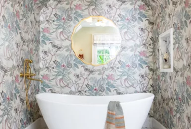 primary suite bathroom tub alcove soacking tub jungle wallpaper african lilac brass tub filler mosaic tile floor serene adventurous design